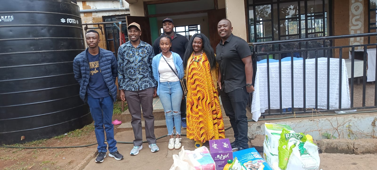 KMC team members with donated essential supplies during a community outreach visit