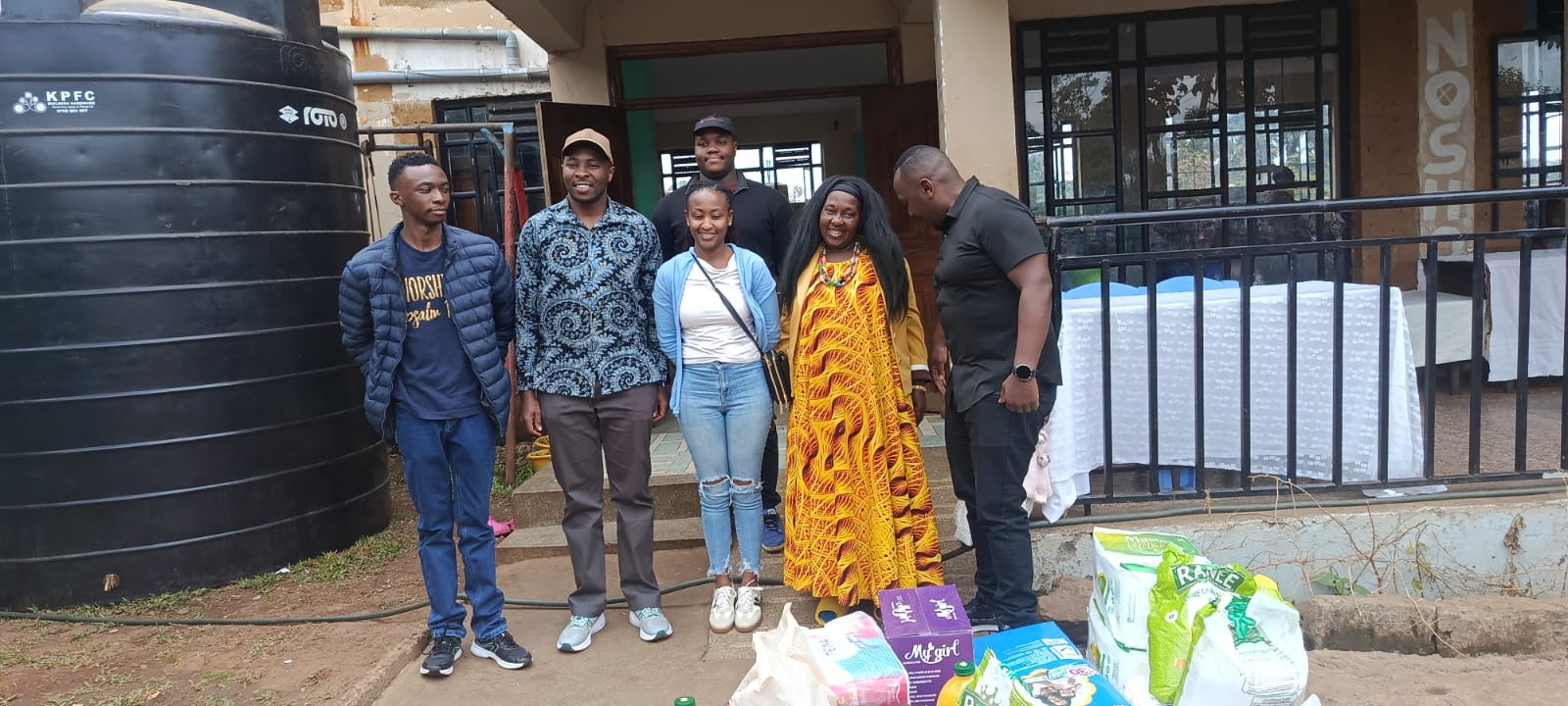 KMC team members with donated essential supplies during a community outreach visit