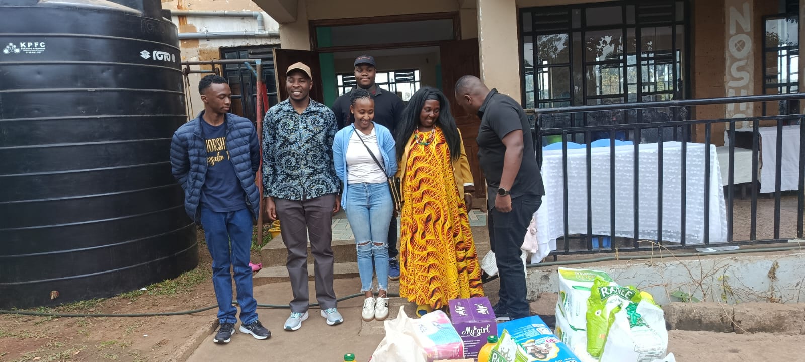 KMC team members with donated essential supplies during a community outreach visit