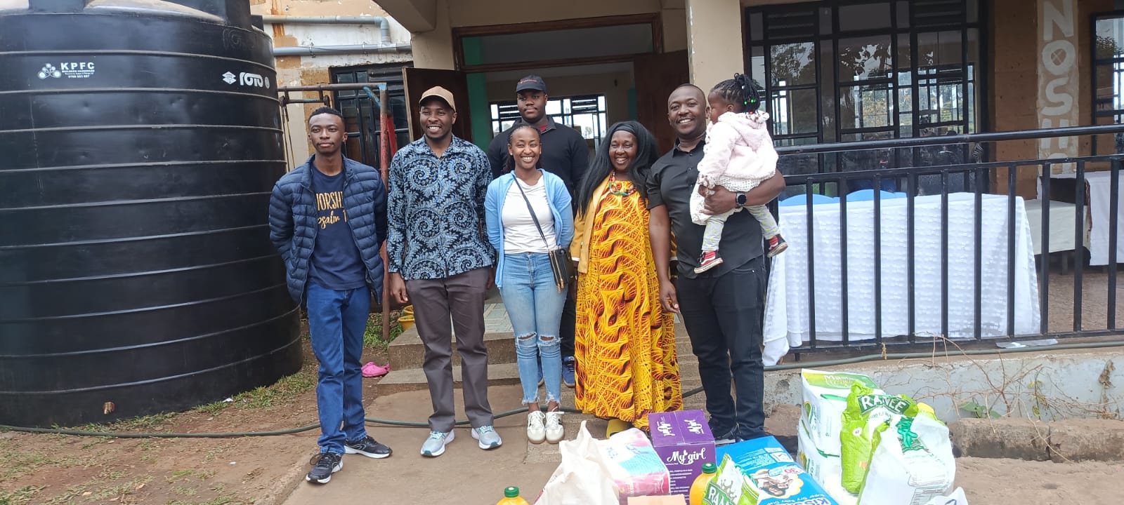 KMC team members with donated essential supplies during a community outreach visit