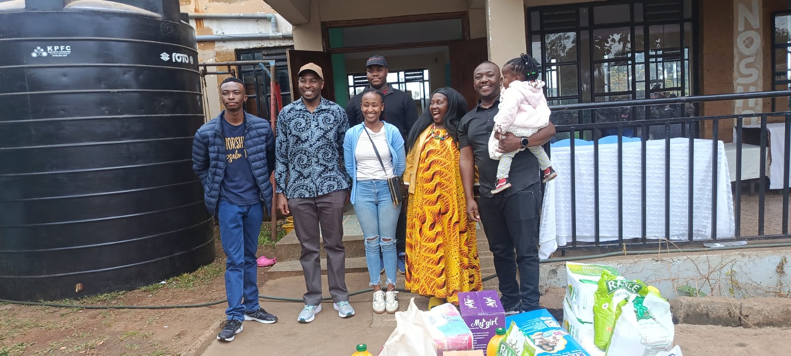 KMC team members with donated essential supplies during a community outreach visit