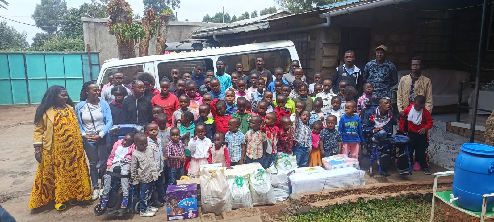 Children, caregivers, and KMC team members gathered during a community outreach visit