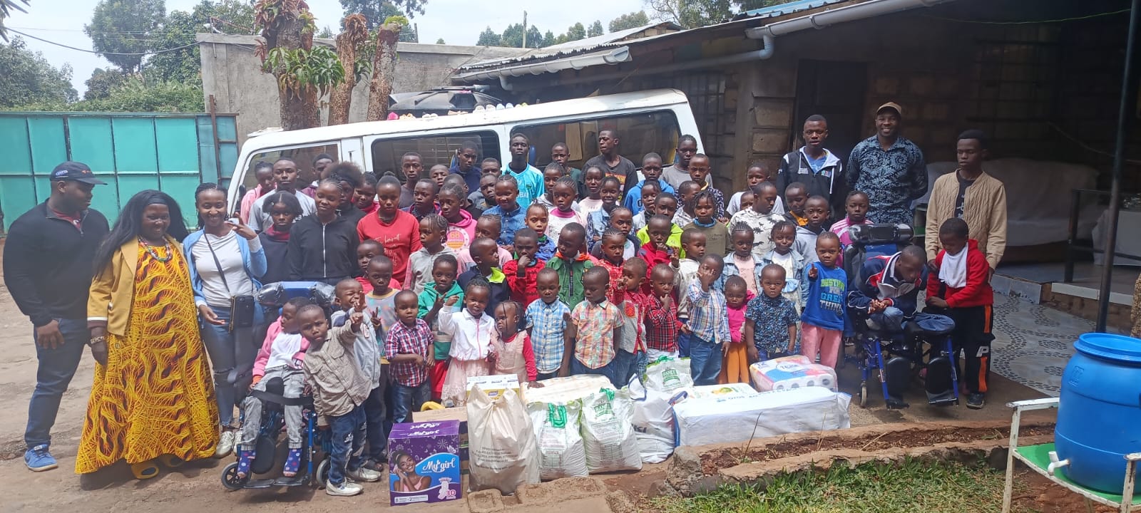 Children, caregivers, and KMC team members gathered during a community outreach visit